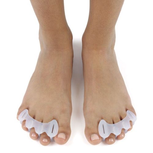 A photo of correct toes clear toe spacers made from silicone. A woman’s feet are shown wearing the correct toes and facing towards the front against a white background.