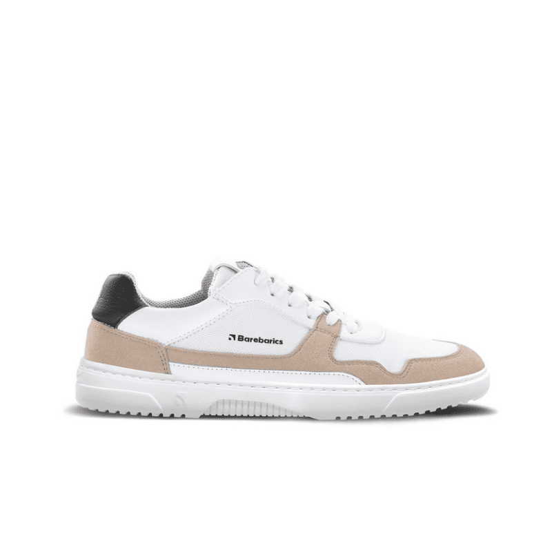 A photo of Barebarics Zing sneakers made with a leather upper and a rubber sole. The sneakers are a white and beige color with perforated spots on the top of the toe box and barebarics branding on the tongue and side. They also have black at the top of the heel. The left sneaker is shown from the side against a white background. #color_white-beige-vegan