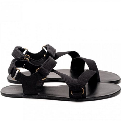 A photo of Black Be Lenka Flexi Sandals made with fabric straps with velcro and a tan leather topped rubber soles. The sandals are a black color and have straps that cross the front of the foot and continue around the mid-foot, ankle, and heel. Both sandals are shown from the right side against a white background in this photo. #color_black