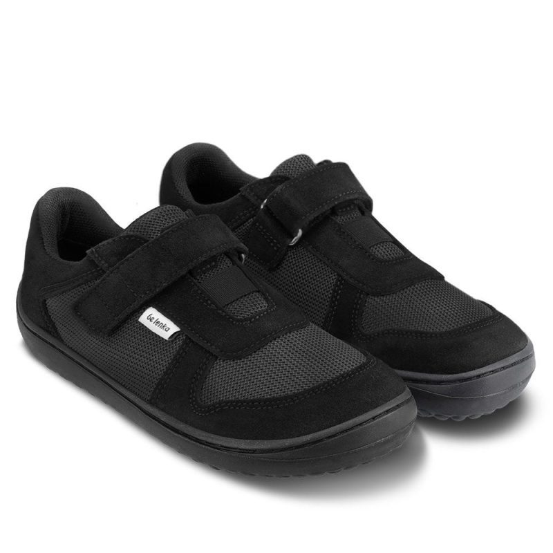 Photo 1 - A photo of Be Lenka Joy kids play shoes in all black. They are made of mesh and suede in a classic sneaker design. A velcro strap at the top of the tongue and elastic band just below are in place of laces. Both shoes are shown facing diagonally right against a white background. Photo 2 - Both shoes are shown from above against a white background. #color_all-black