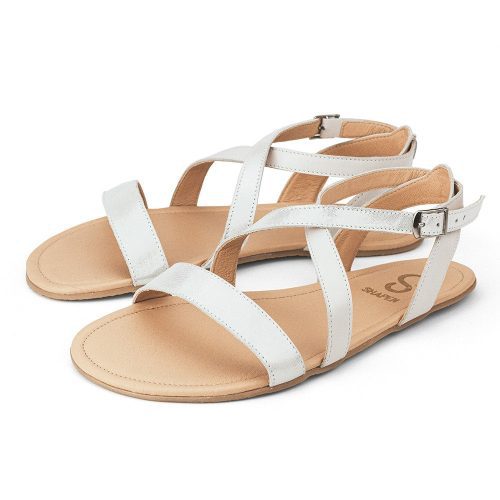 A photo of White Shapen Calla Sandals made with leather and tan rubber soles. The sandals have a slight sparkle on the front strap across the toes and one of the straps that make an x over the mid foot. The other strap of the x is a flat white. Both sandals are shown facing diagonally left against a white background. #color_white