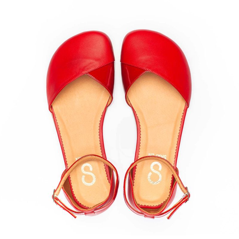 A photo of Shapen Poppy D’orsay dressy flats with a leather upper and rubber soles. The flats are a cherry red color with a heel cup and dainty ankle strap, the inside of the sole are a beige color. Both flats are shown from the top facing up against a white background. #color_cherry