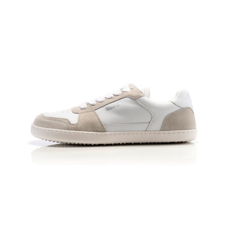 A photo of Shapen ReWind leather sneakers in white. Shoes are a classic chunky sneaker design with beige suede color blocks surrounding the toe guard, laces, and heels. Left shoe is shown facing left here against a white background. #color_white