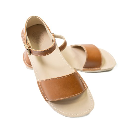 Brown Zeezoo Siren leather Sandals. The sandals have a front foot strap, a leather ankle strap, and a heel cup. Left shoe is shoen facing right with the right shoe heel propped on the left against a white background. #color_brown